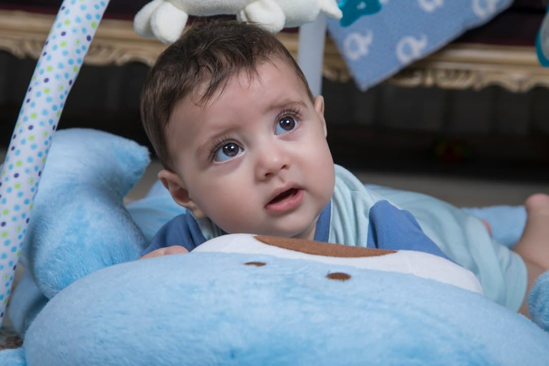 a baby laying on a blue stuffed animal
