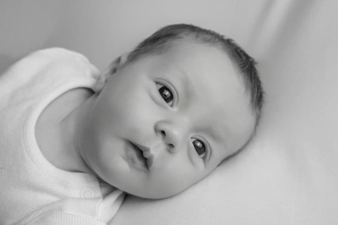 A baby looking directly forward in black and white