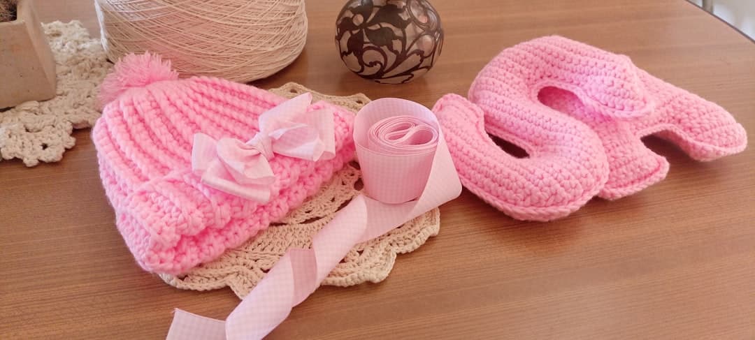 Pink knitted baby hat and booties with ribbon