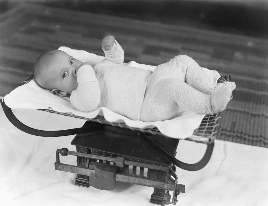 a black and white photo of a baby in a sled