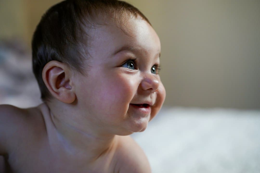 A happy baby smiles in the sunlight