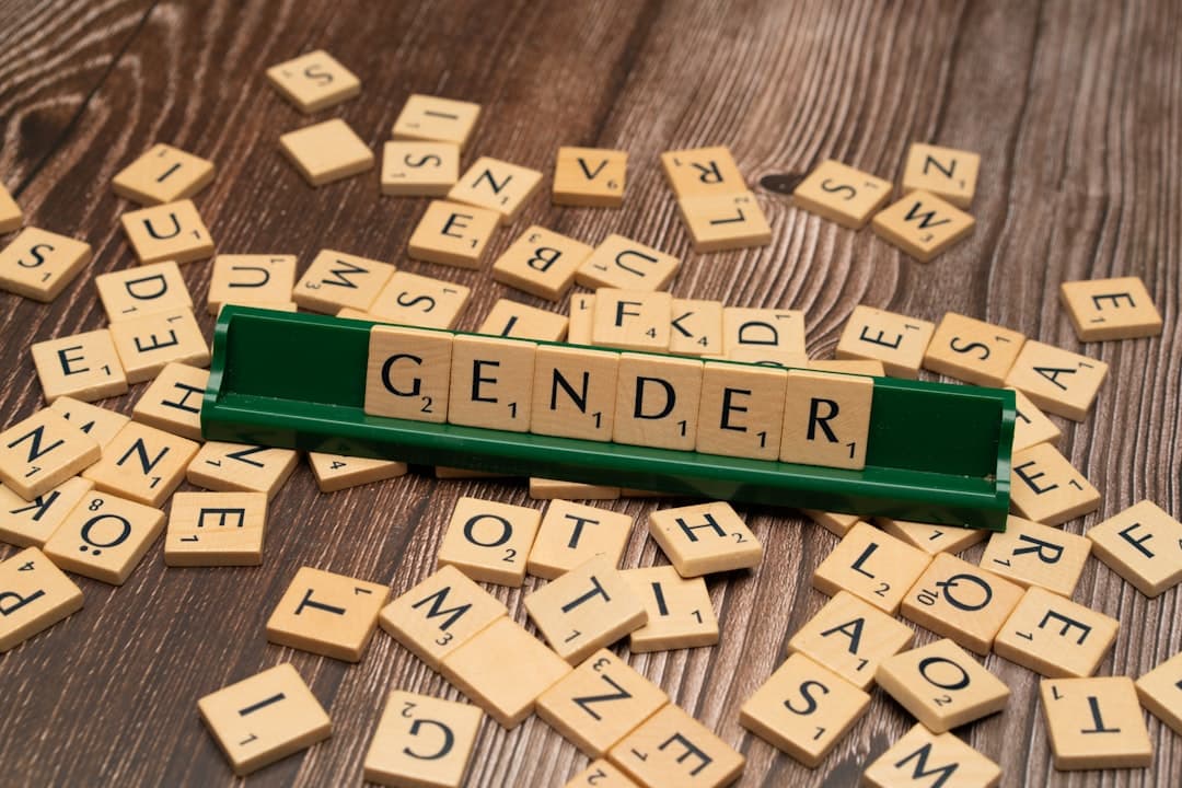 scrabble tiles spelling out the word gender on a wooden table