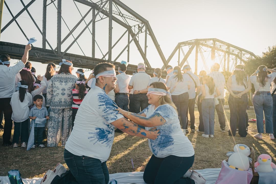 Couple kneeling outdoors with guests watching