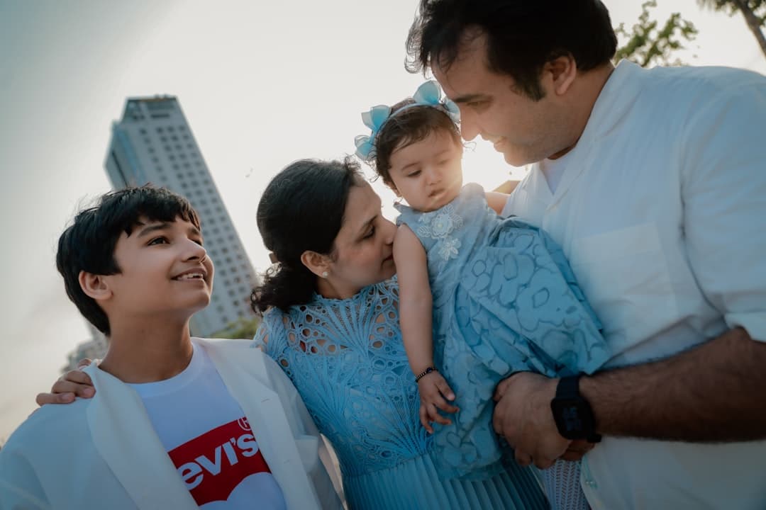 Family posing together with a skyscraper in background